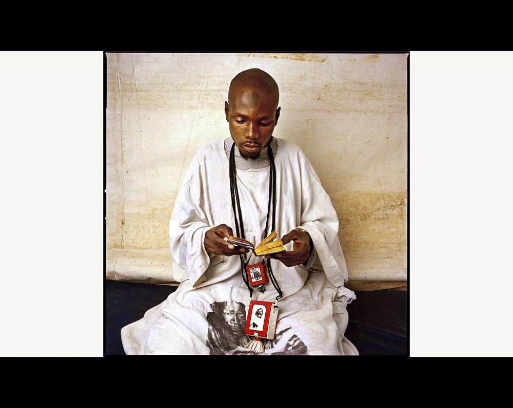 Un musulman du Sénégal lisant le Coran. Ici, en 2013, un Baye Fall, d'un groupe religieux proche des Mourides. ©  Laurent Gudin