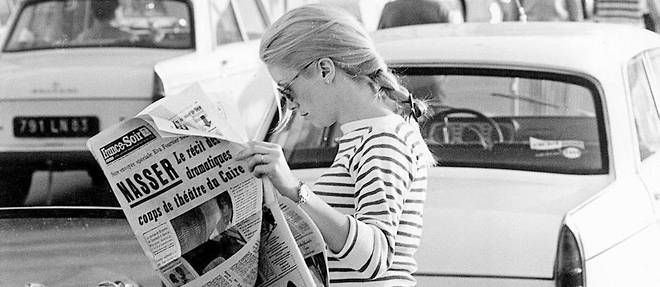Catherine Deneuve en vacances a Saint Tropez lisant le journal "France-Soir" dans les annees 1960