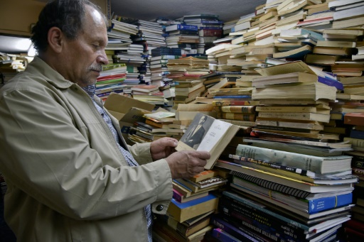José Alberto Gutierrez au milieu des livres entassés dans sa bibliothèque à son domicile de Bogota le 18 mai 2017 © GUILLERMO LEGARIA AFP