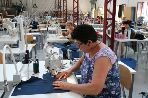Des eùmployées travaillent sur des vêtements de la marque Coq Sportif dans l'usine de Romilly-sur-Seine, le 21 juin 2017 © FRANCOIS NASCIMBENI AFP