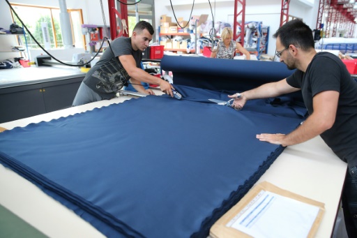 Des employés coupent une pièce de textile à l'usine de la marque Coq Sportif, le 21 juin 2017 à Romilly-sur-Seine © FRANCOIS NASCIMBENI AFP
