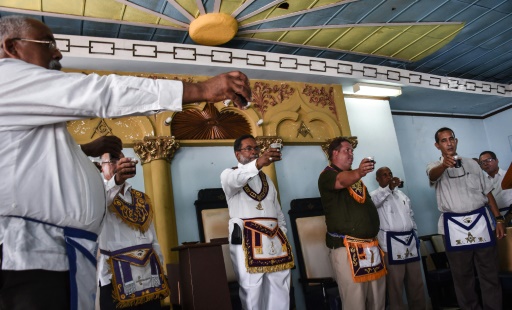 Lazaro Cuesta (c), grand Maître de la Grande loge de Cuba, porte un toast avec des "frères" lors d'une cérémonie au temple maçonnique de La Havane, le 27 juin 2017 © ADALBERTO ROQUE AFP