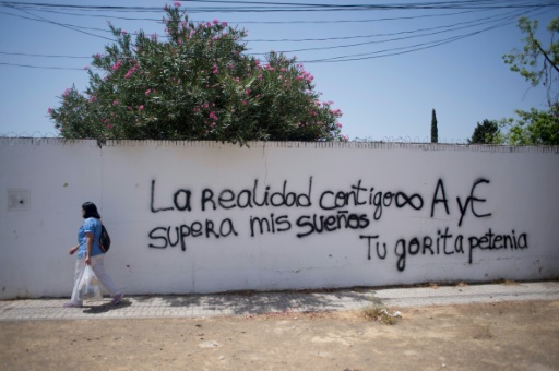 Une femme passe le long d'un mur dans le quartier des Pajaritos, le plus pauvre d'Espagne, le 12 juillet 2017 à Séville © JORGE GUERRERO AFP/Archives