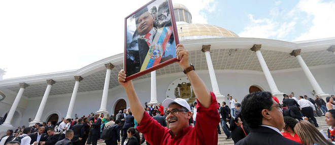 Un elu de l'Assemblee constituante brandit un portrait de Chavez, le 4 aout  devant le Parlement. 