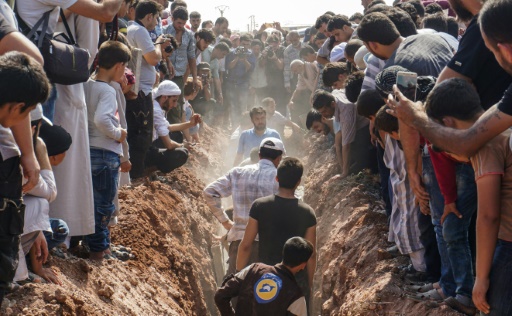Des casques blancs, célèbres secouristes en terrain rebelle en Syrie enterrent sept de leurs camarades abattus à Sarmine, une ville de la province d'Idleb , le 12 août 2017 © OMAR HAJ KADOUR AFP