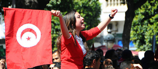 (Image d'illustration) Une femme brandit un drapeau national lors d'une manifestation pour celebrer l'independance de la Tunisie, mardi 20 mars 2012 a Tunis.