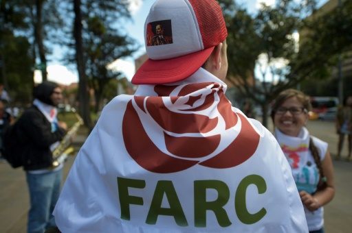 Un militant des Farc enveloppé dans un drapeau avec un logo du nouveau parti politique "révolutionnaire" à Bogota, le 1er septembre 2017 © Raul Arboleda AFP