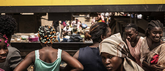 Dans le quartier de Viana a Luanda, des vendeuses protegent leurs aliments au passage d'un train.