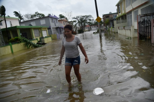 Une habitante du quartier de Puerto Nuevo, à San Juan,marche dans les rues inondées après le passage de l'ouragan Maria sur Porto Rico, le 20 septembre 2017 © HECTOR RETAMAL AFP