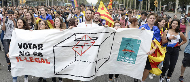 Des manifestants pro-referendum defilent ce vendredi en Catalogne. "Voter n'est pas illegal", est-il ecrit sur leur banniere.
 

