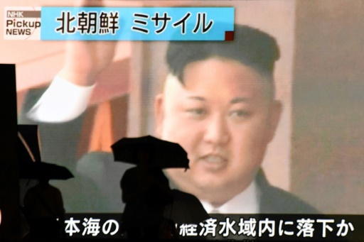 Photo d'archive montrant des piétons à Tokyo passant devant un portrait du leader nord-coréen Kim Jong-Un sur grand écran, le 4 juillet 2017  © Kazuhiro NOGI AFP/Archives