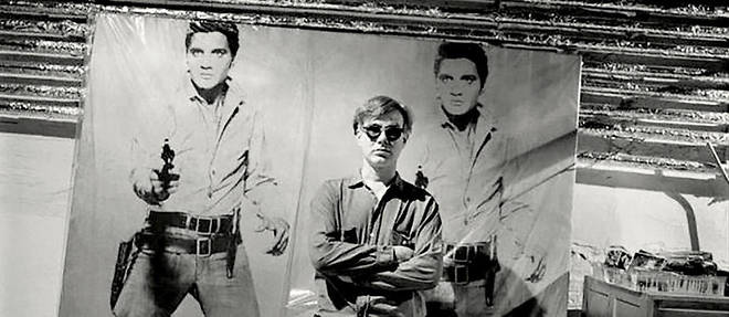 Andy Warhol pose devant son "Double Portrait" d'Elvis.