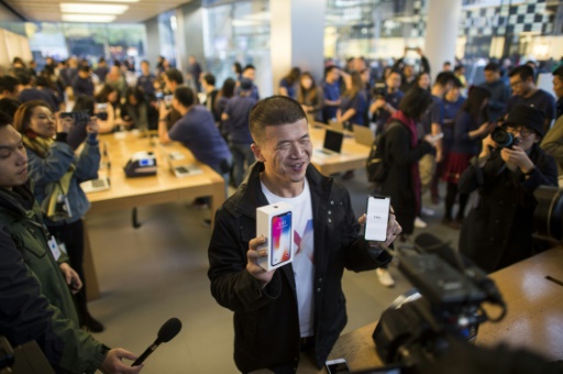 Un homme pose avec son nouvel iPhone X dans une boutique Apple à Pékin, le 3 novembre 2017 © FRED DUFOUR AFP