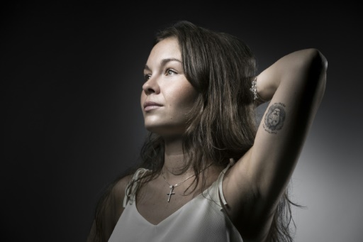 Manon Hautecoeur, qui se trouvait au Petit Cambodge lors des attentats du 13 novembre 2015 à Paris, montre son tatouage lors d'une séance photo le 21 juillet 2017 © JOEL SAGET AFP
