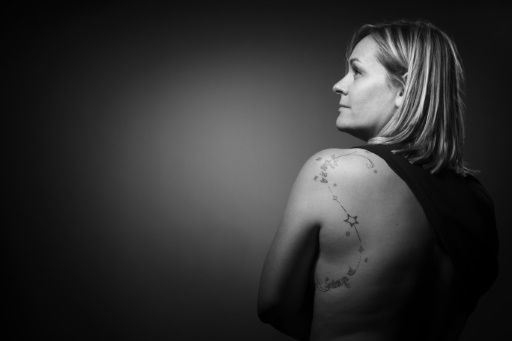 Fanny, qui a perdu son compagnon Olivier lors de l'attaque du Bataclan montre son tatouage, le 28 août 2017 lors d'une session photo à Paris © JOEL SAGET AFP