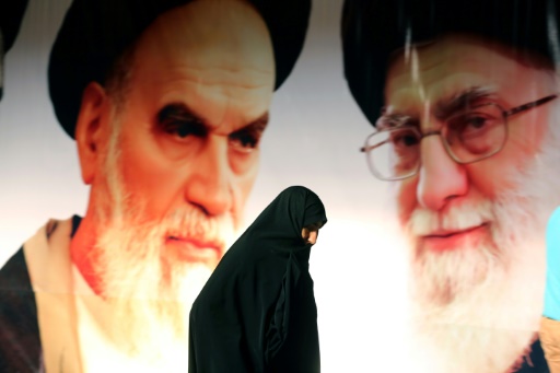 Photo d'une Iranienne passant devant un portrait du guide suprême, l'Ayatollah Ali Khamenei (D), et du fondateur de la République islamique, l'Ayatollah Ruhollah Khomeini (G), le 1er février 2015 près de Téhéran © ATTA KENARE AFP/Archives