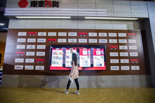 Vue prise le 11 novembre 2017 montrant une femme tentant de choisir des produits à livrer sur un écran dans le centre commercial T-Mall à Shanghai. Les ventes de produits importés et étrangers ont connu un boom sur les sites de ventes en ligne en Chine © STR AFP/Archives