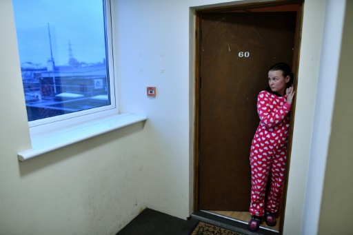 Sandra Rumkiene sur le palier de son appartement situé dans une ancienne tour de bureaux réaménagés en logements, le 20 novembre 2017 à Londres © BEN STANSALL AFP