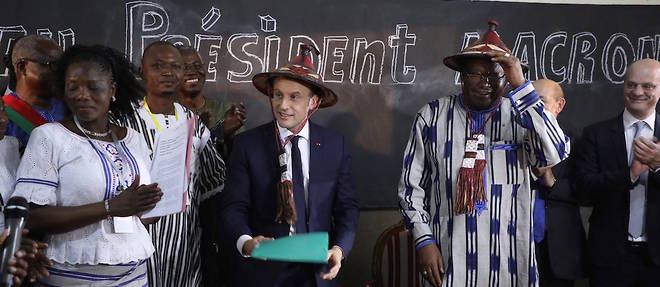 Le pr&#233;sident fran&#231;ais, Emmanuel Macron, avec sur la t&#234;te un chapeau traditionnel burkinab&#232;, aux c&#244;t&#233;s du pr&#233;sident Roch Marc Christian Kabor&#233;, qui fait de m&#234;me dans une salle de classe de l'&#233;cole Lagm-Taaba, &#224; Ouagadougou, le 28 novembre 2017.