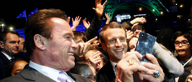 Emmanuel Macron et Arnold Schwarzenegger devant la tour Eiffel illumin&#233;e des couleurs du One Planet Summit qui s'est tenu &#224; Paris le 12 d&#233;cembre.&#160;