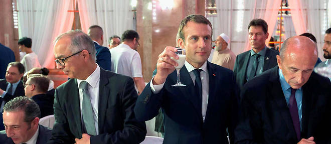 Emmanuel Macron, le traditionnel verre de lait &#224; la main, et son ministre de l&#8217;Int&#233;rieur, G&#233;rard Collomb, lors du repas c&#233;l&#233;brant la rupture du je&#251;ne organis&#233; par le Conseil fran&#231;ais du culte musulman, le 20&#160;juin 2017, &#224; Paris.