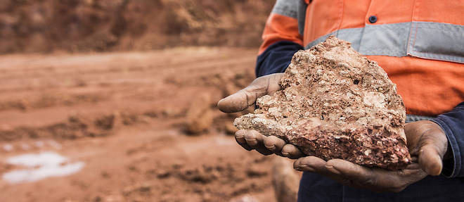 Un ouvrier detient une bauxite brute de haute qualite a la mine de bauxite Sangaredi exploitee par la Compagnie des bauxites de Guinee (CBG), pres de Boke, en Guinee, le mardi 8 septembre 2015.