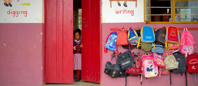Une petite fille ferme la porte de sa classe &#224; Kampala.