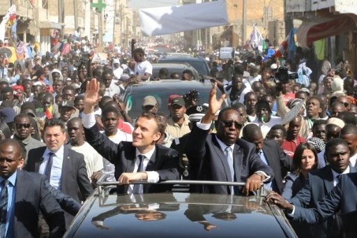 Les présidents français et sénégalais, Emmanuel Macron et Macky Sall, saluent la foule lors d'une visite à Saint-Louis, dans le nord du Sénégal, le 3 février 2018. © ludovic MARIN POOL/AFP