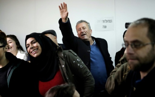Photo du père d'Ahed Tamimi, Bassem (C), saluant sa fille de la main lors de l'ouverture du procès de la jeune palestinienne le 13 février 2018 devant le tribunal militaire d'Ofer, en Cisjordanie occupée © THOMAS COEX AFP