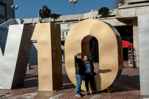 Un couple prend un selfie devant le monument à la "Renaissance" érigé pour le 10e anniversaire de l'indépendance du Kosovo à Pristina, le 17 février 2018 © Armend NIMANI AFP