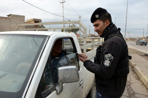 Un policier irakien vérifie l'identité d'un conducteur d'une camionnette à un barrage routier de Mossoul en Irak, le 22 février 2018  © Ahmad MUWAFAQ AFP