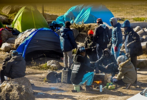 Des migrants près de leurs tentes dans un campement à la périphérie de Calais, le 8 mars 2018 © Philippe HUGUEN AFP