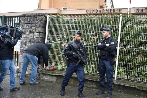 Un passant dépose des fleurs devant la gendarmerie nationale le 24 mars 2018 à Carcassonne après l'attaque qui a tué 4 peronnes dont un gendarme © Pascal PAVANI AFP
