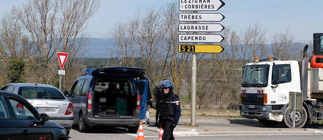 French gendarmes block the access to Trebes, where a man took hostages at a supermarket on March 23, 2018 in Trebes, southwest France.  At least one person was feared dead after a gunman claiming allegiance to the Islamic State group fired shots in a hostage-taking at a supermarket in southwest France, police said. / AFP PHOTO / ERIC CABANIS