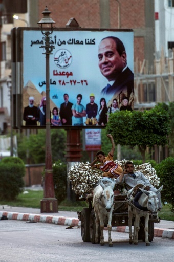 Une photo prise le 20 mars dans les rues de Sohag, une ville au sud du Caire, montrant une affiche géante du président Abdle Fattah al-Sissi © KHALED DESOUKI AFP