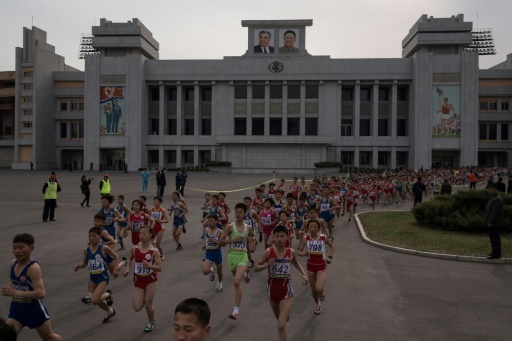 Compétiteurs nord-coréens devant le stade Kim Il Sung lors du marathon de Pyongyang, le 8 avril 2018 © Ed JONES AFP