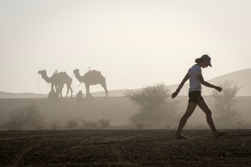Un coureur marche dans le campement pendant une tempête de sable à Timgaline, dans le désert marocain, le 7 avril 2018 © JEAN-PHILIPPE KSIAZEK AFP