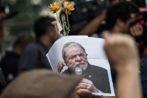 Un partisan de Lula arbore une photo de l'ex-président le 7 avril 2018 au cours d'une messe à la mémoire de son épouse. © NELSON ALMEIDA AFP