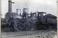  Des cheminots posent avec une locomotive à vapeur et son tender dans une gare, en 1890. 