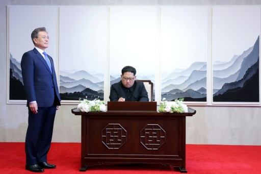 Le leader nord-coréen Kim Jong Un signe le livre d'honneur à côté du président sud-coréen Moon Jae-in (g) à la Maison de la paix, lors du sommet intercoréen le 27 avril 2018à Panmunjom © Korea Summit Press Pool Korea Summit Press Pool/AFP