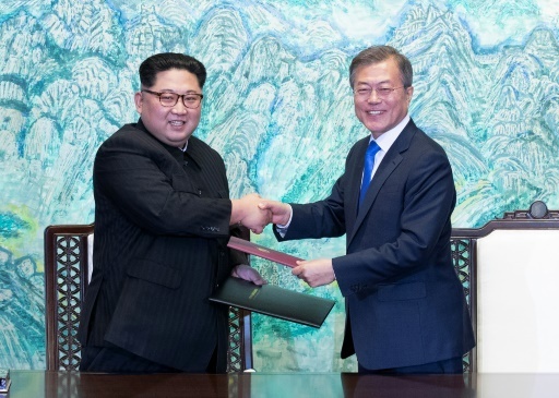 L président sud-coréen Moon Jae-in (d) et le leader nord-coréen Kim Jong Un échangent des documents signés pendant le sommet intercoréen, le 27 avril 2018 à Panmunjom © Korea Summit Press Pool Korea Summit Press Pool/AFP
