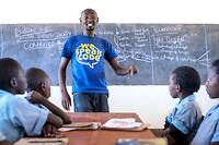  A Nairobi, au Kenya, un jeune enseignant devant des élèves à l'école primaire de Kabuki. De plus en plus, le système scolaire veut sensibiliser les enfants aux nouvelles technologies. 