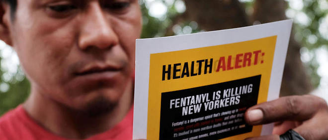 Un consommateur d'heroine lit un tract alertant sur les risques du fentanyl dans le Bronx de New York en aout 2017. 