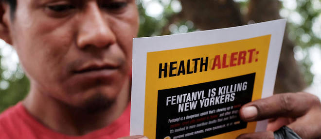 Un consommateur d'heroine lit un tract alertant sur les risques du fentanyl dans le Bronx de New York en aout 2017. 