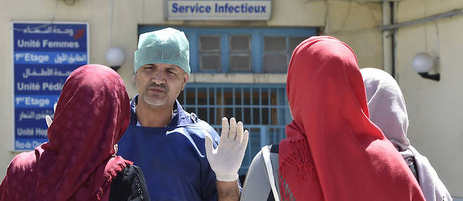 Devant l'hopital de Boufarik, un mecdecin et des Algeriennes alors que le cholera s'est declare fin aout 2018.