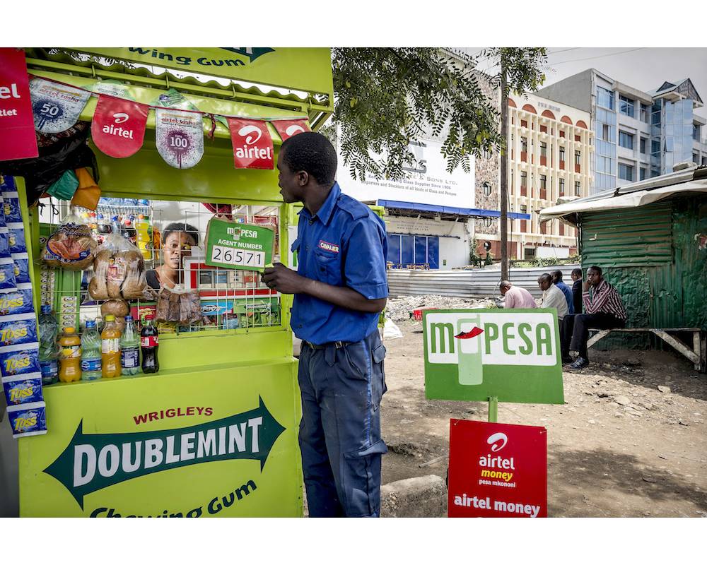 Un client utilise le système M-Pesa devant un point de vente de l'opérateur Safaricom.  ©  Sven Torfinn/panos:REA