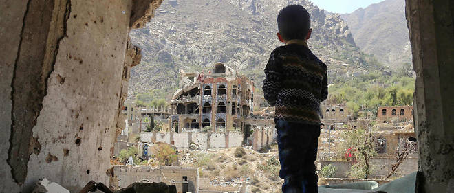 Un enfant yemenite observe les decombres d'une maison apres un bombardement. 