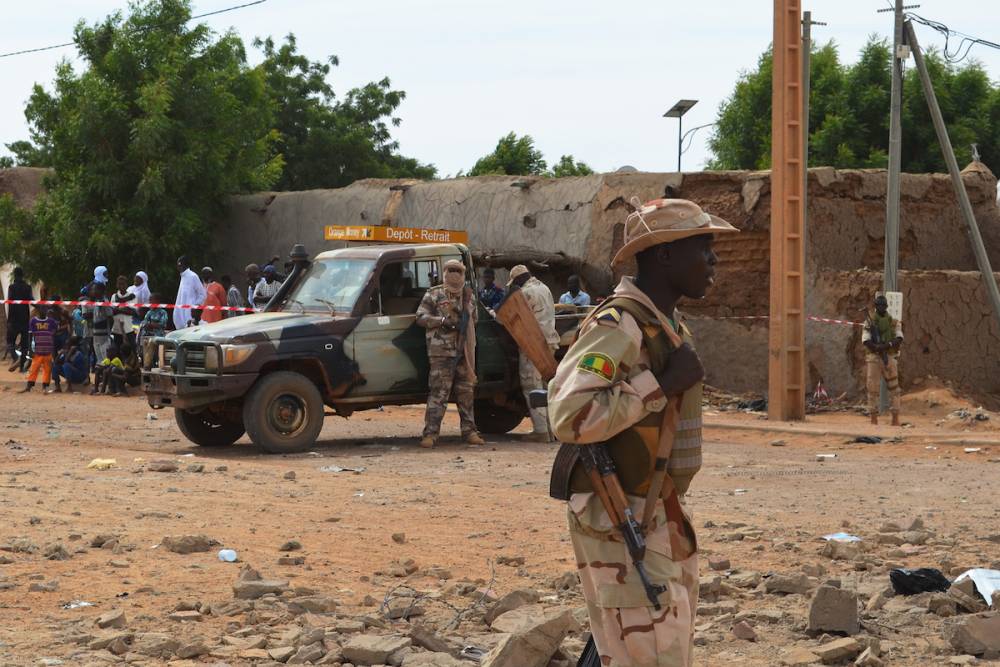 Un soldat malien se tient le 13 novembre 2018 à Gao, à côté d'un bâtiment détruit, après un attentat-suicide à la voiture piégée qui a fait trois morts.  © - AFP