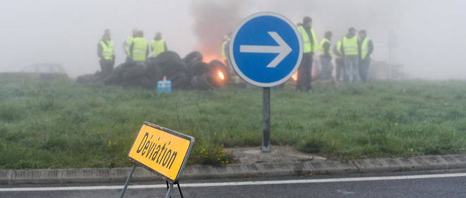Au rond-point de Carbonne (31) dans un epais brouillard, une trentaine de manifestants des Gilets jaunes avec des tracteurs filtrent les vehicules tout en brulant quelques pneus et des slogans sur les tracteurs.