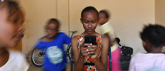 La question de l'acces a Internet est toujours posee en Afrique. Pour les jeunes, c'est un enjeu majeur. Ici, Imelda Mumbi, 13 ans, tient son smartphone alors qu'elle etudie en ligne a l'aide d'une application a Riruta, a Nairobi, le 8 novembre 2018. 